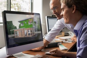 Two men looking at a computer rendition of a property development