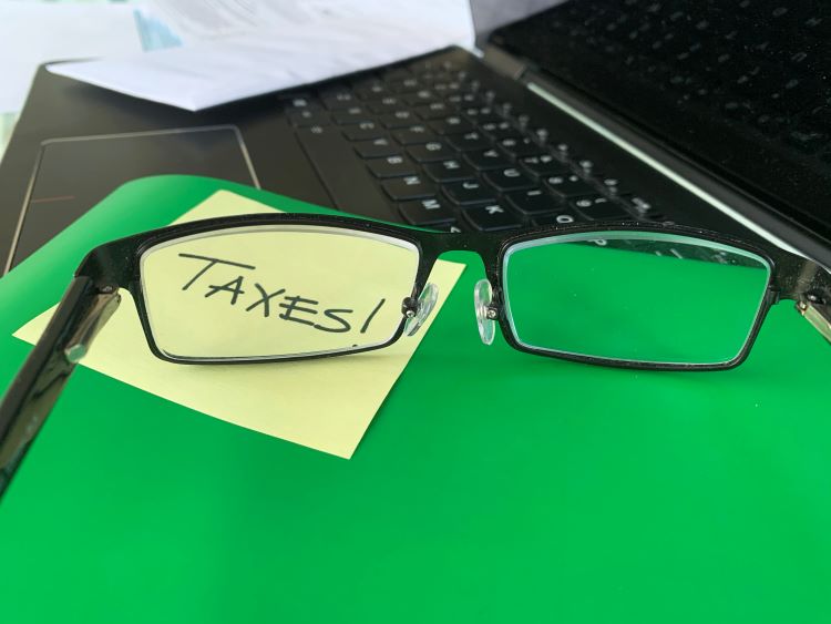reading glasses magnify sticky note with the word TAXES